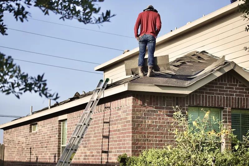 Professional roofer working on a residential roof in Quail Hollow